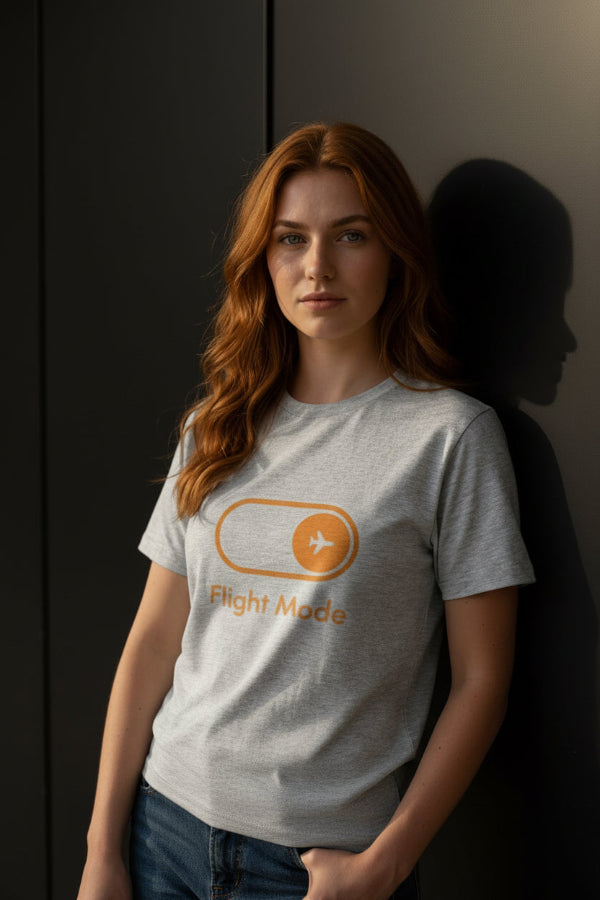 Model in a gray BlooomiT cotton t-shirt with a graphic leaning against a stone wall.
