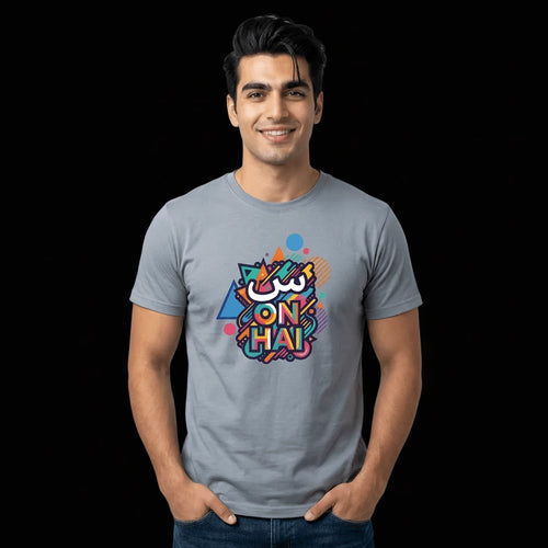 A man wearing a light gray crewneck t-shirt with a colorful graphic print on the chest that reads 'SCENE ON HAI'. The background is solid black.