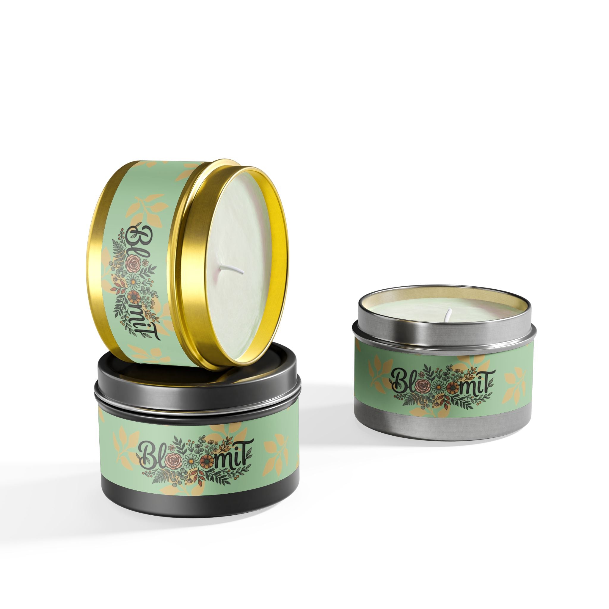 Two small travel candles in decorative tins with floral designs on a white background